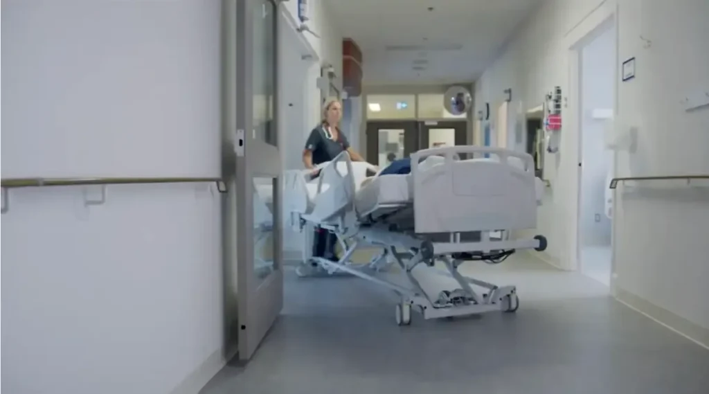 Pousser un patient dans son lit pour le faire entrer dans une chambre d'hôpital
